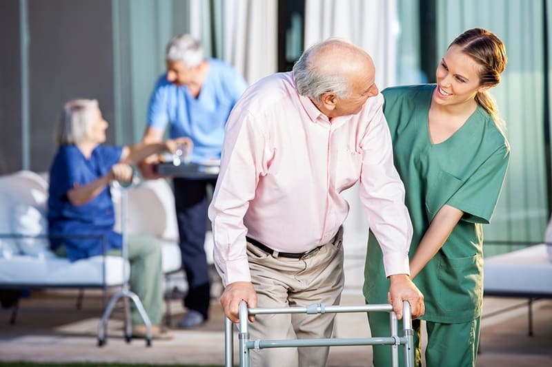 Nurse Smiling at Elderly Man Seeking Healthcare